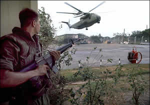 A Marine provides security as Sikorsky CH-53 helicopters land at the Defense Attaché Office compound. Via Wikimedia Commons. Image Author: Dirck Halstead